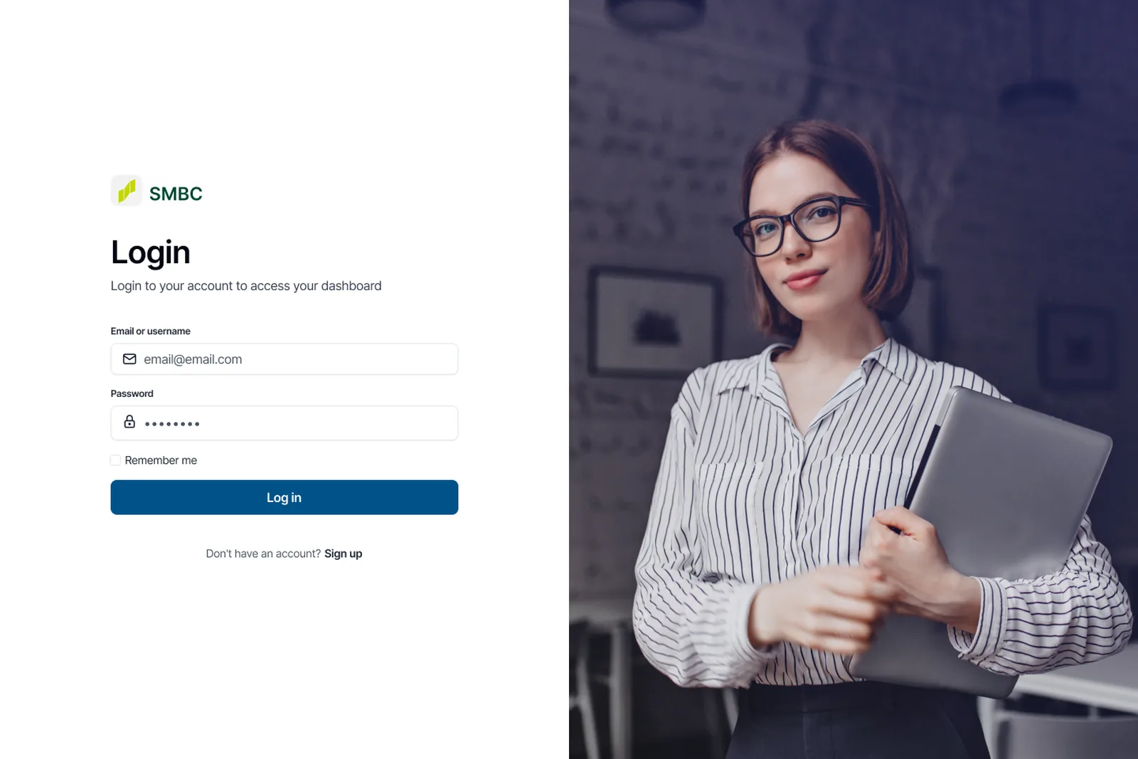 The sign-in screen: the SMBC mark above email or username and password fields, a remember me checkbox and a log in button, set beside a full-height photograph of an analyst holding a laptop.