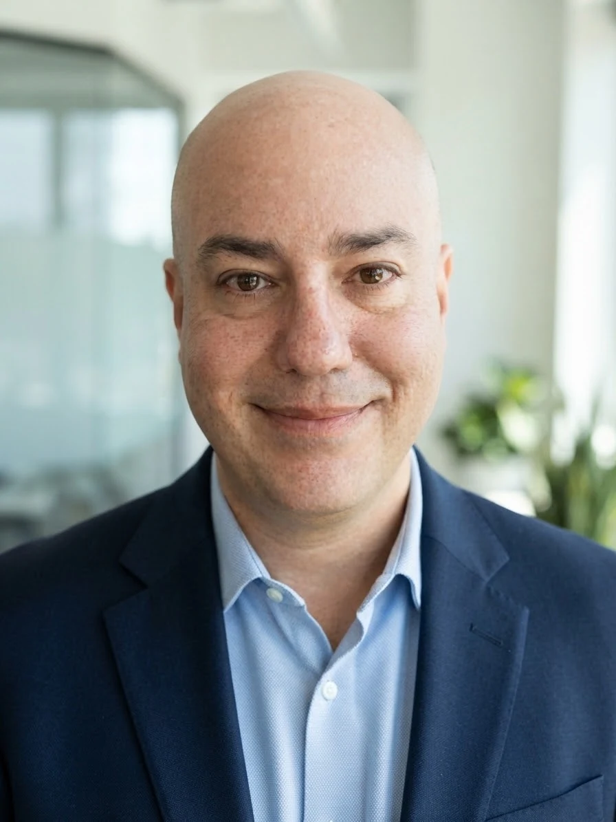 Todd Crawford, photographed in an office in a navy jacket and light blue shirt.